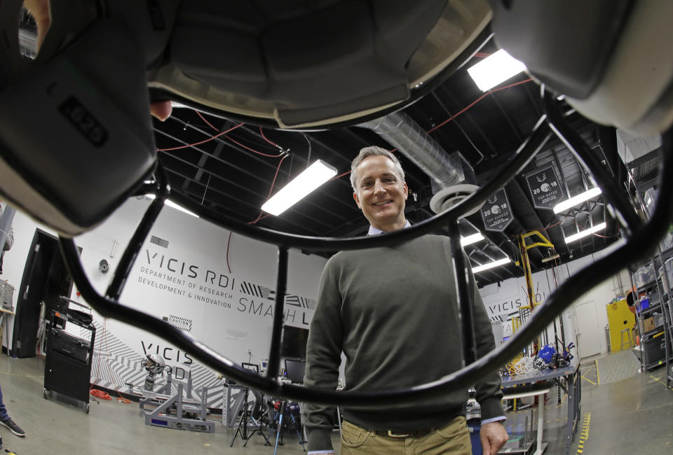 In this photo taken May 23, 2019, Dave Marver, CEO of VICIS, a Seattle-based company that makes football helmets, poses for a photo, seen through the face mask of one of his company's NFL football helmets in Seattle in the company's testing lab. VICIS announced on Monday, July 1, the cap is intended for use with youth flag football and the quickly expanding competitive 7-on-7 football played during the offseason for youth and high school programs. (AP Photo/Ted S. Warren)