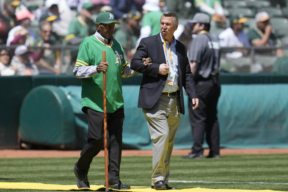 FILE - Former Oakland Athletics player Vida Blue, left, walks with Athletics Vice President of Stadium Operations David Rinetti during a ceremony honoring the Athletics' 1973 World Series championship team before a baseball game between the Athletics and the New York Mets in Oakland, Calif., Sunday, April 16, 2023. Blue, a hard-throwing left-hander who became one of baseball’s biggest draws in the early 1970s and helped lead the brash Oakland Athletics to three straight World Series titles, has died. He was 73. The A’s said Blue died Saturday, May 6, 2023. (AP Photo/Jeff Chiu, File)