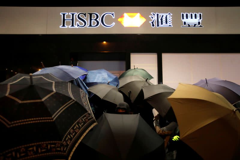 An anti-government protester looks through umbrellas as protesters vandalize ATM machines during an anti-government demonstration on New Year's Day to call for better governance and democratic reforms in Hong Kong