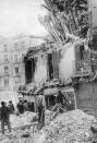 <p>Varios hombres tratan de limpiar los restos de un edificio que ha quedado prácticamente destruido tras un bombardeo de los sublevados en 1936. (Foto: Hulton Archive / Getty Images).</p> 