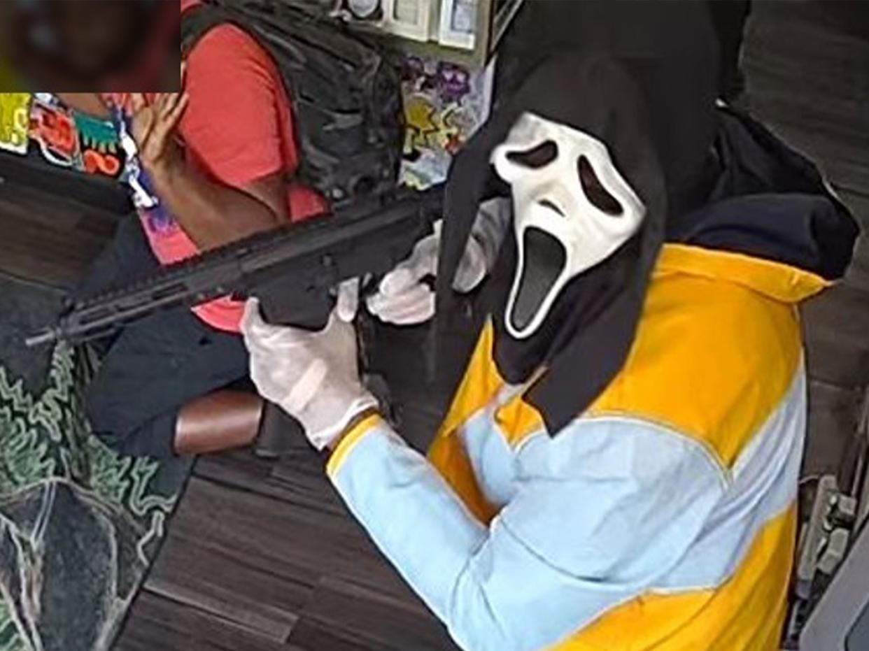 Surveillance video shows gunman in Ghostface mask and two others rob smoke shop in Queens, police said.