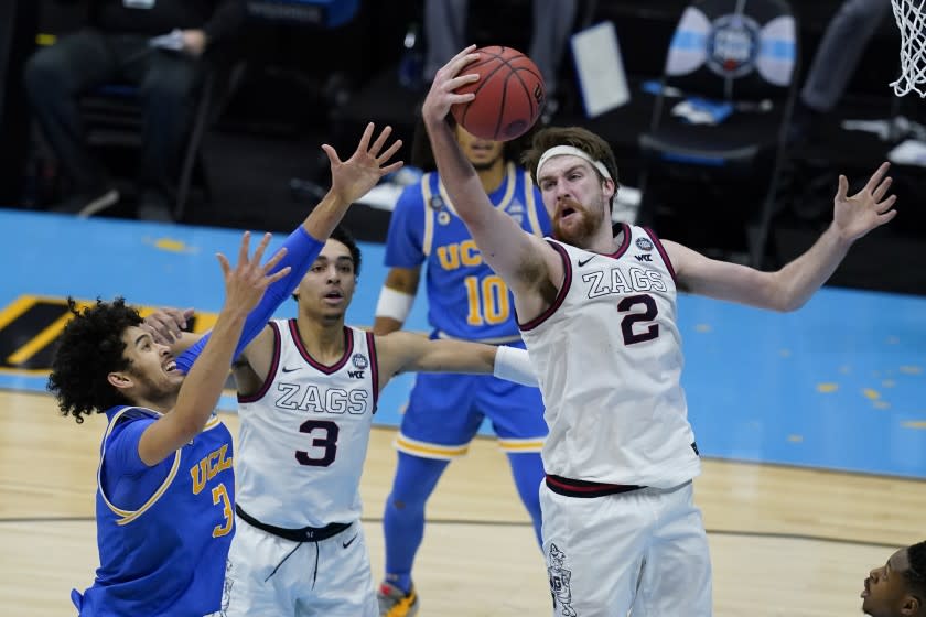 Gonzaga forward Drew Timme (2) grabs a rebound over UCLA guard Johnny Juzang (3) during overtime in a men's Final Four NCAA college basketball tournament semifinal game, Saturday, April 3, 2021, at Lucas Oil Stadium in Indianapolis. (AP Photo/Darron Cummings)