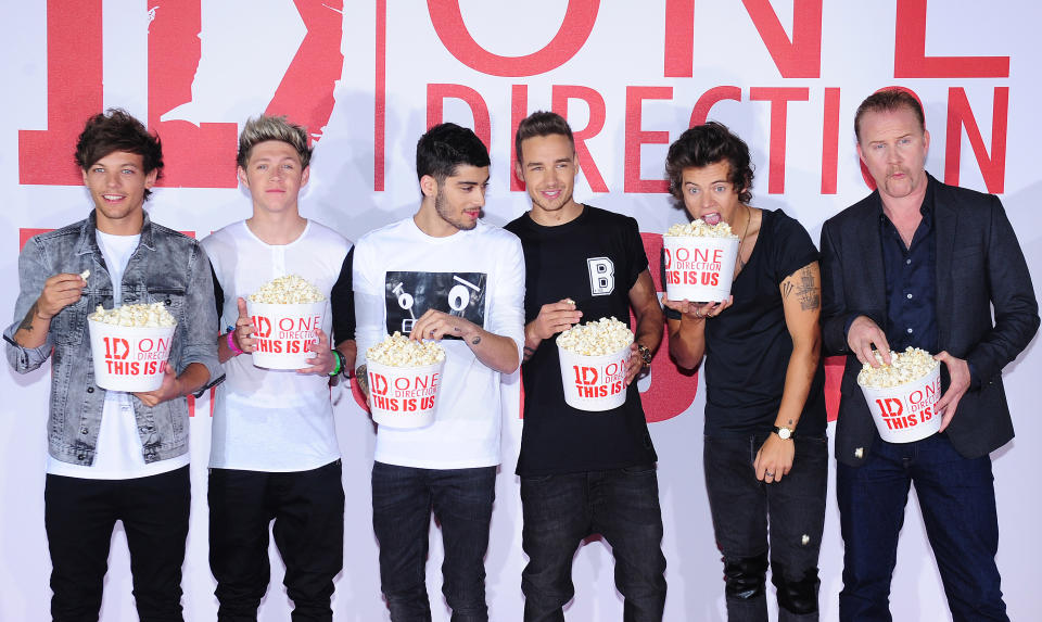 One Direction, from left to right, Louis Tomlinson, Niall Horan, Zayn Malik, Liam Payne and Harry Styles with documentary filmmaker Morgan Spurlock at a photocall to promote the film, This Is Us, at the Sky Studios, London, Monday Aug. 19, 2013. The film is an intimate all-access look at life on the road for the global music phenomenon. (AP Photo, PA, Ian West) UNITED KINGDOM OUT