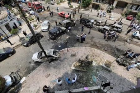 People stand around burnt cars at the site of a car bomb attack on the convoy of Egyptian public prosecutor Hisham Barakat near his house at Heliopolis district in Cairo, Egypt, in this June 29, 2015 file photo. REUTERS/Mohamed Abd El Ghany/Files