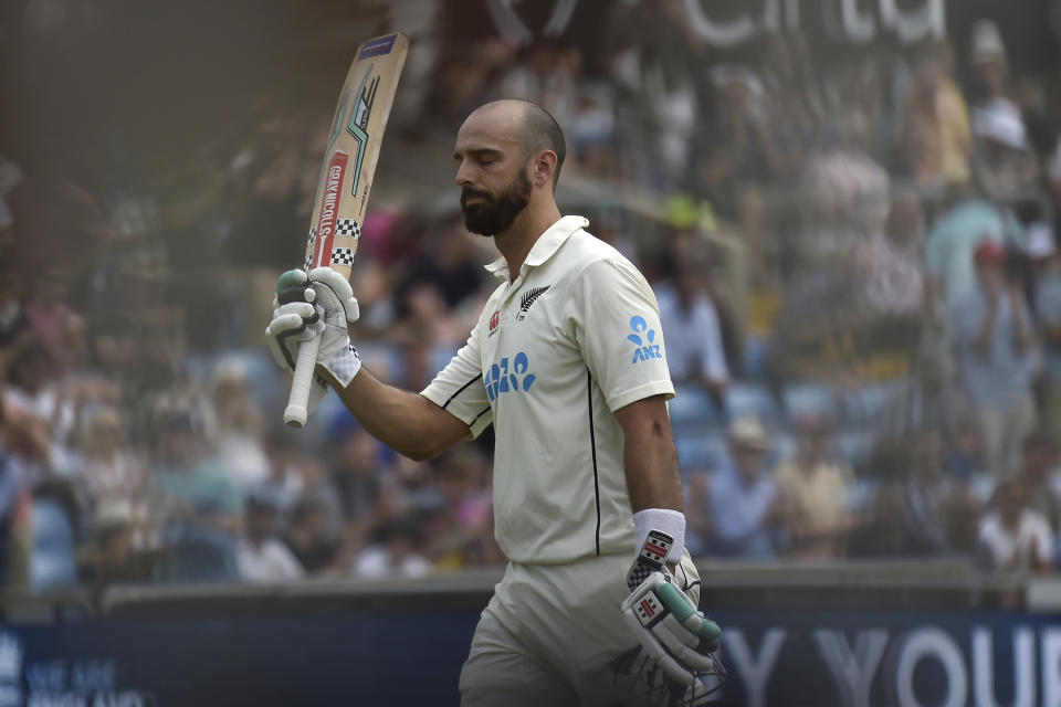 New Zealand's Daryl Mitchell raises his bat to acknowledge the applause from the crowd as he walks off the field after losing his wicket during the second day of the third cricket test match between England and New Zealand at Headingley in Leeds, England, Friday, June 24, 2022. (AP Photo/Rui Vieira)