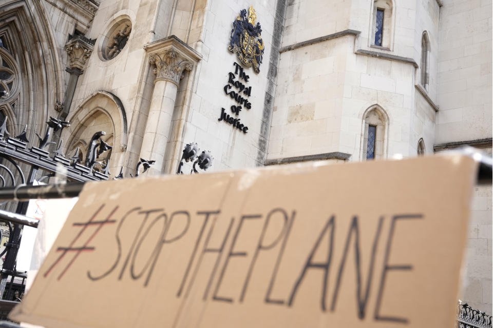 A placard left outside the High Court where the ruling on Rwanda deportation flights is taking place, in London Monday, June 13, 2022. Opponents of the British government’s plan to deport migrants to Rwanda prepared for an appeals court hearing Monday amid the political backlash following reports that Prince Charles had privately described the policy as “appalling.” (AP Photo/Alastair Grant)