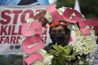 A protester holds a slogan during a rally as they commemorate International Human Rights Day, Saturday, Dec. 10, 2022, in Manila, Philippines. Hundreds of people marched in the Philippine capital on Saturday protesting what they said was a rising number of extrajudicial killings and other injustices under the administration of President Ferdinand Marcos Jr. (AP Photo/Aaron Favila)