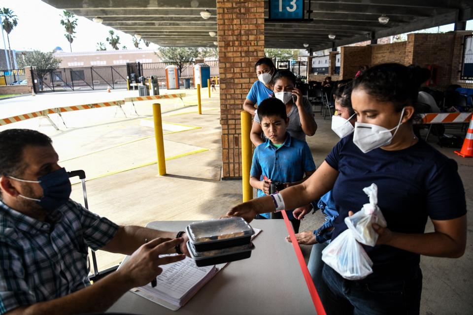 Migrants, most from Central America, receive donated food as they wait for their coronavirus tests after they were dropped off by the U.S. Customs and Border Protection at a bus station near the Gateway International Bridge between the cities of Brownsville, Texas, and Matamoros, Mexico, on March 15.