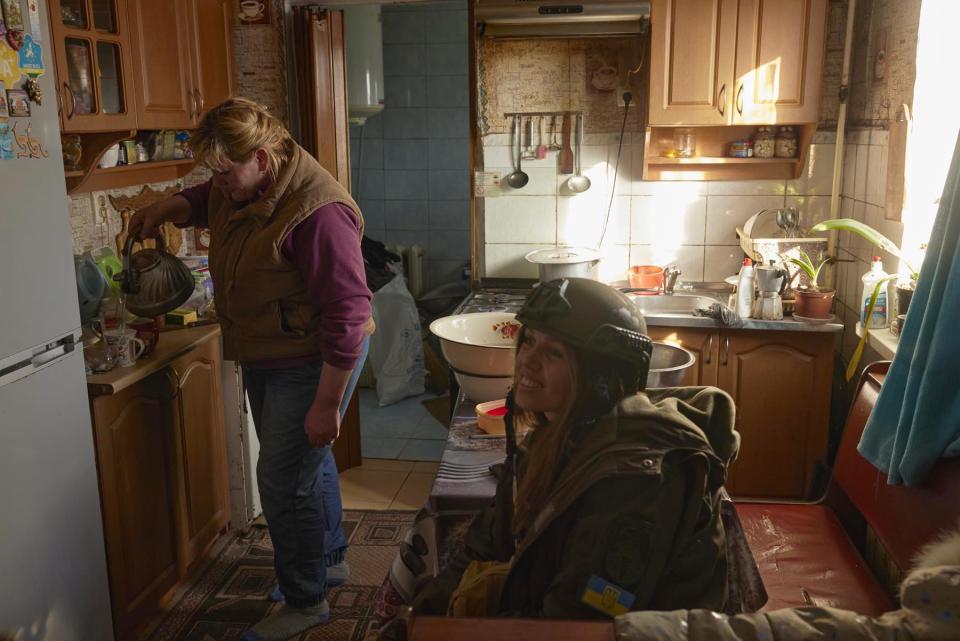 Julia sits in the home of a local resident as she prepares teas and coffees for the New Dawn team in Bilozherka, Kherson Oblast, Ukraine on March 8, 2023.