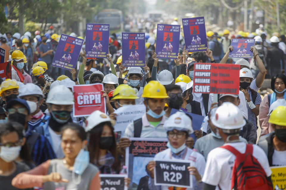 Anti-coup protesters display placrds in Yangon, Myanmar Wednesday, March 10, 2021. Protesters against the military takeover in Myanmar carried homemade shields and moved with more caution and agility Tuesday, adapting their tactics to the escalating violence from security forces not reluctant to use lethal force to break up crowds. (AP Photo)