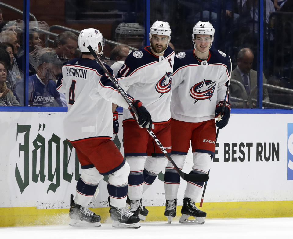 Columbus Blue Jackets left wing Nick Foligno (71) celebrates his goal against the Tampa Bay Lightning with center Alexandre Texier (42) and defenseman Scott Harrington (4) during the second period of Game 1 of an NHL Eastern Conference first-round hockey playoff series Wednesday, April 10, 2019, in Tampa, Fla. (AP Photo/Chris O'Meara)