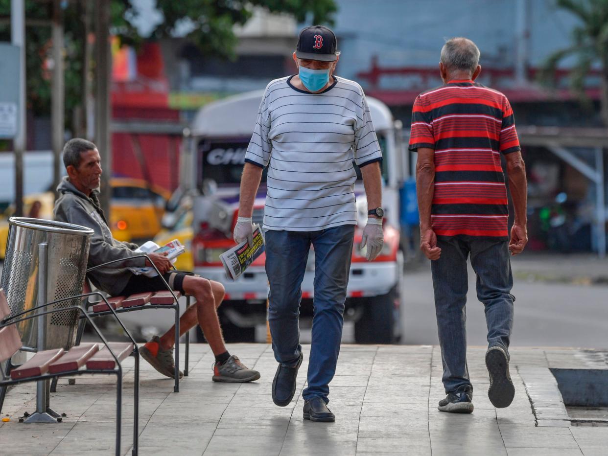 A man wearing a face mask as a precautionary measure against the spread of the new coronavirus, COVID 19, walks in Panama City on March 25, 2020. (Luis ACOSTA : AFP) 