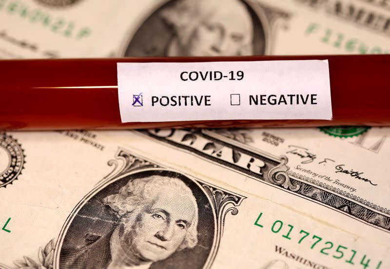 FILE PHOTO: Picture illustration of a test tube labelled with the coronavirus placed on U.S. dollar banknotes