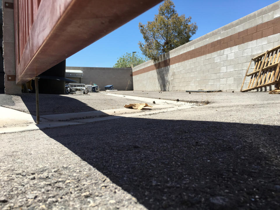 A coffin, mops and coolers used to transport body parts lie in an abandoned courtyard outside a warehouse once shared by a funeral home and the body broker Southern Nevada Donor Services in suburban Las Vegas, Nevada, U.S. July 19, 2016. The operation shuttered in early 2016, a few weeks after authorities were called to a report of a man thawing a frozen torso in the courtyard. Picture taken July 19, 2016. To match Special Report USA-BODIES/BROKERS REUTERS/John Shiffman