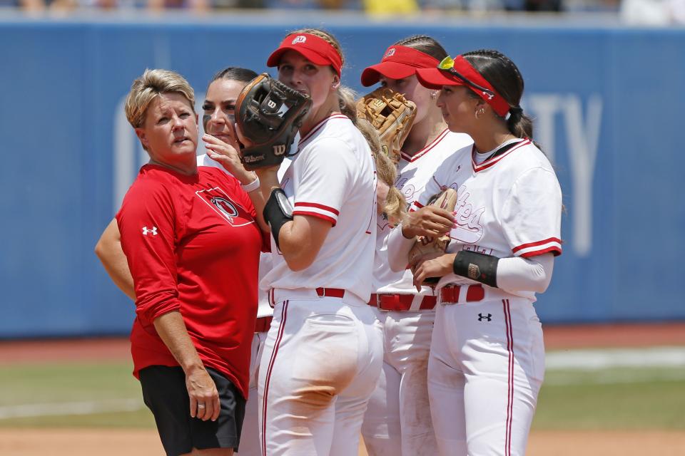 Utah coach Amy Hogue, left, talks to her players during the second inning of a Women’s College World Series game against Washington, Friday, June 2, 2023, in Oklahoma City. The Utes fell to the Huskies and will play Oklahoma State in a win-or-go-home game Friday evening. | Nate Billings, Associated Press