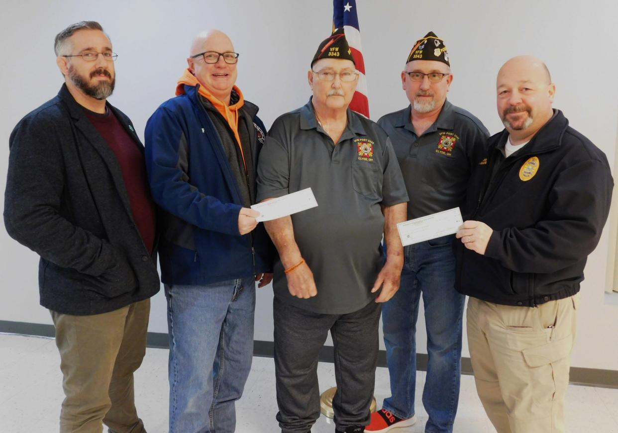 Clyde City Manager Justin LaBenne, from left, Clyde Fire Chief Paul Fiser, and Police Chief Monte Campbell, far right receive two $10,000 checks from Clyde VFW Trustee Mo Marks, center, and Post Commander Brian Moore at the VFW on Wednesday night.