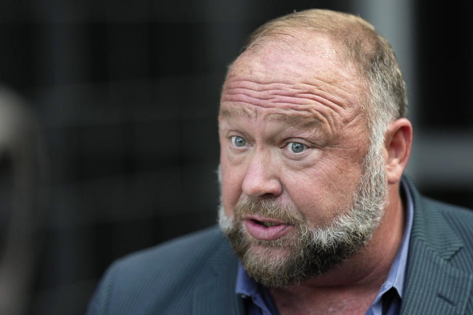 Right-wing conspiracy theorist Alex Jones speaks to the media after arriving at the federal courthouse for a hearing in front of a bankruptcy judge Friday, June 14, 2024, in Houston. The judge is expected to rule on whether to liquidate Jones' assets to help pay the $1.5 billion he owes for his false claims that the Sandy Hook Elementary School shooting was a hoax. (AP Photo/David J. Phillip)