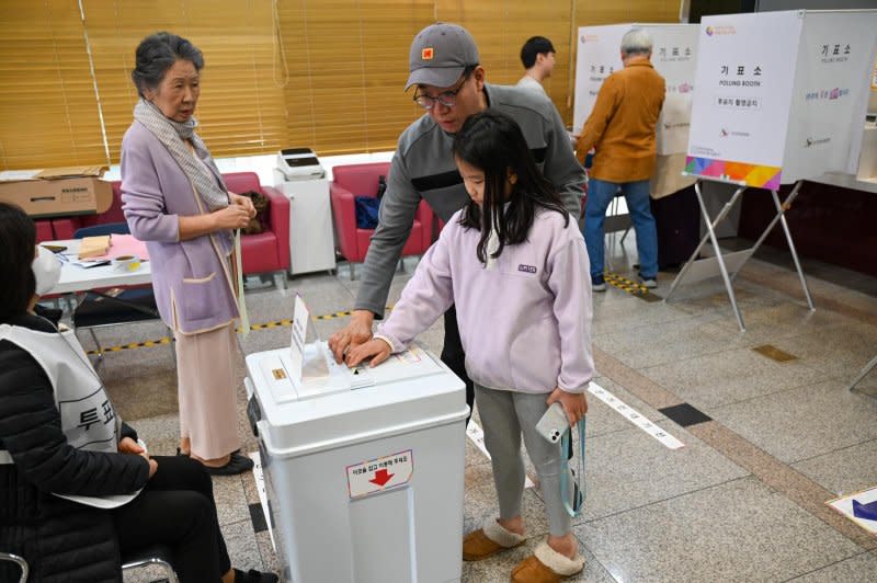 A father and daughter cast his ballot at a polling station in the Gwangjin District of Seoul on Wednesday. Photo by Thomas Maresca/UPI