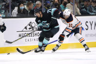 Seattle Kraken right wing Joonas Donskoi (72) skates ahead of Edmonton Oilers center Derek Ryan during the first period of an NHL hockey game Friday, Dec. 3, 2021, in Seattle. (AP Photo/Elaine Thompson)