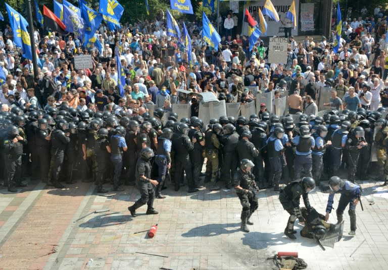 Police officers help a wounded colleague during clashes with activists of radical Ukrainian parties, including the Ukrainian nationalist party Svoboda (Freedom), in Kiev on August 31, 2015