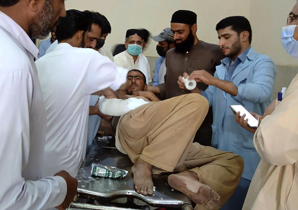 A man injured in a bus accident is treated at a hospital in Khuzdar, a remote district in the Pakistan's southwestern Baluchistan province, Friday, June 11, 2021. A speeding bus carrying pilgrims overturned on a highway and fell into a ravine in a remote area in southwestern Pakistan before dawn on Friday, killing more than a dozen and injuring scores of people, police and officials said. (AP Photo/Younis Baloch)