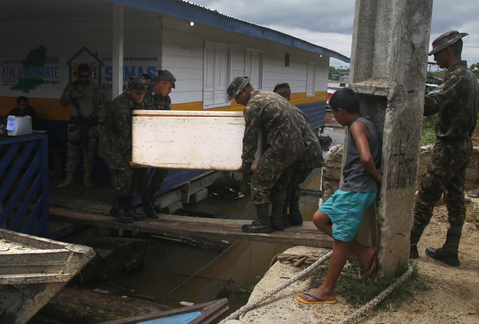 Army soldiers carry a container with seized fish illegally caught in Atalaia do Norte, Amazonas state, Brazil, Saturday, June 11, 2022. According to the police, a wildcat fisherman is the main suspect of the disappearance of British journalist Dom Phillips and Indigenous affairs expert Bruno Pereira, and authorities say illegal fishing near the Javari Valley Indigenous Territory, where Phillips and Pereira went missing last Sunday has raised the tension with local Indigenous groups in the isolated area near the country's border with Peru and Colombia. (AP Photo/Edmar Barros)