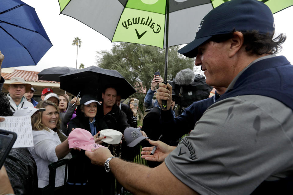 Phil Mickelson signs autographs after posting a 12-under-par 60 in the first round of the Desert Classic golf tournament at La Quinta Country Club on Thursday, Jan. 17, 2019, in La Quinta, Calif. (AP Photo/Chris Carlson)