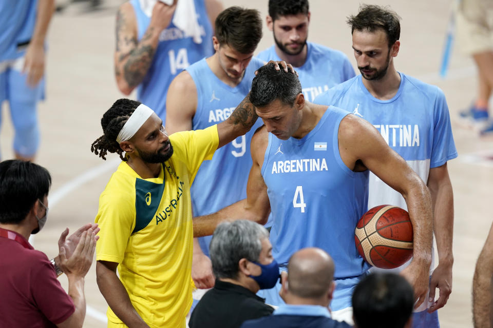 Australia's Patty Mills, left, greets Argentina's Luis Scola (4) after a men's basketball quarterfinal round game at the 2020 Summer Olympics, Tuesday, Aug. 3, 2021, in Saitama, Japan. (AP Photo/Charlie Neibergall)