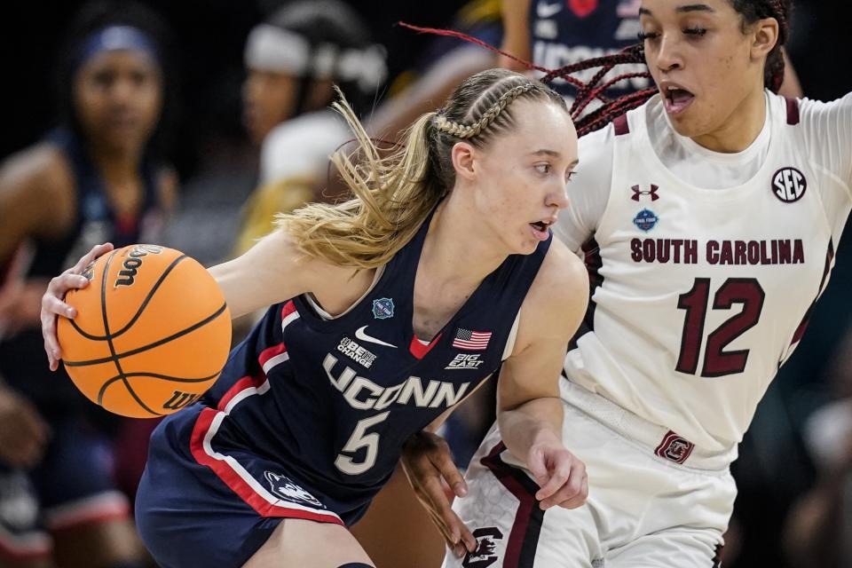 FILE - UConn's Paige Bueckers tries to get past South Carolina's Brea Beal during the Women's Final Four NCAA tournament Sunday, April 3, 2022, in Minneapolis. Bueckers tore the ACL in her left knee and will miss the entire 2022-23 season, the school announced Wednesday, Aug. 3, 2022. (AP Photo/Charlie Neibergall, File)