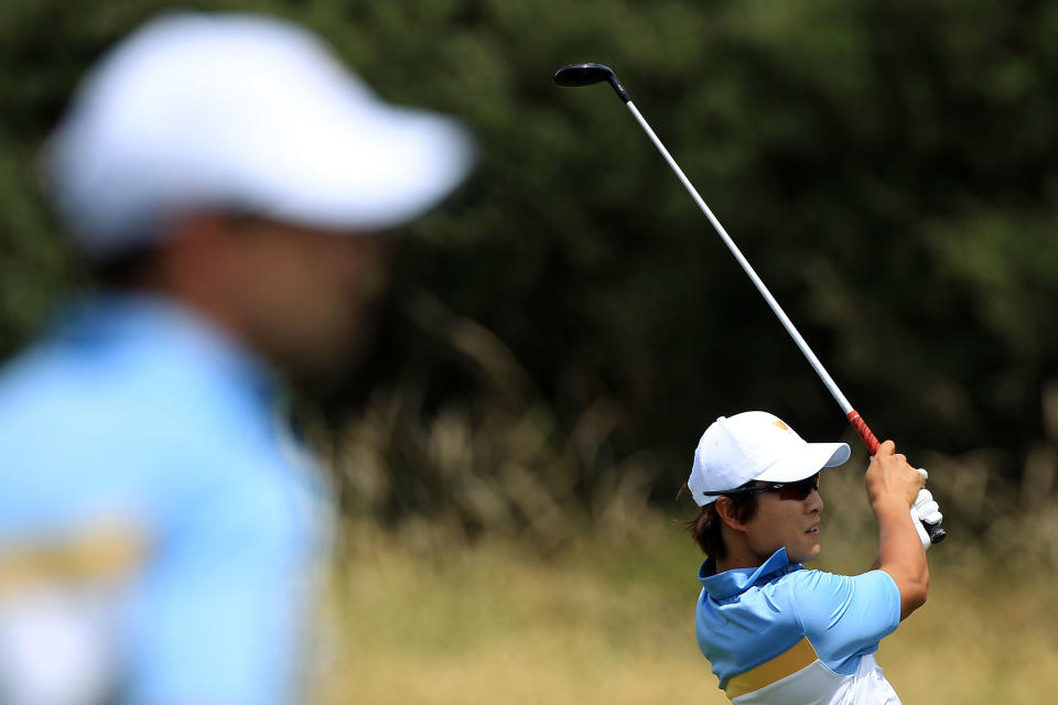 MELBOURNE, AUSTRALIA - NOVEMBER 18: K.T. Kim of the International Team hits his tee shot on the eighth hole as teammate Adam Scott watches during the Day Two Four-Ball Matches of the 2011 Presidents Cup at Royal Melbourne Golf Course on November 18, 2011 in Melbourne, Australia. (Photo by Scott Halleran/Getty Images)