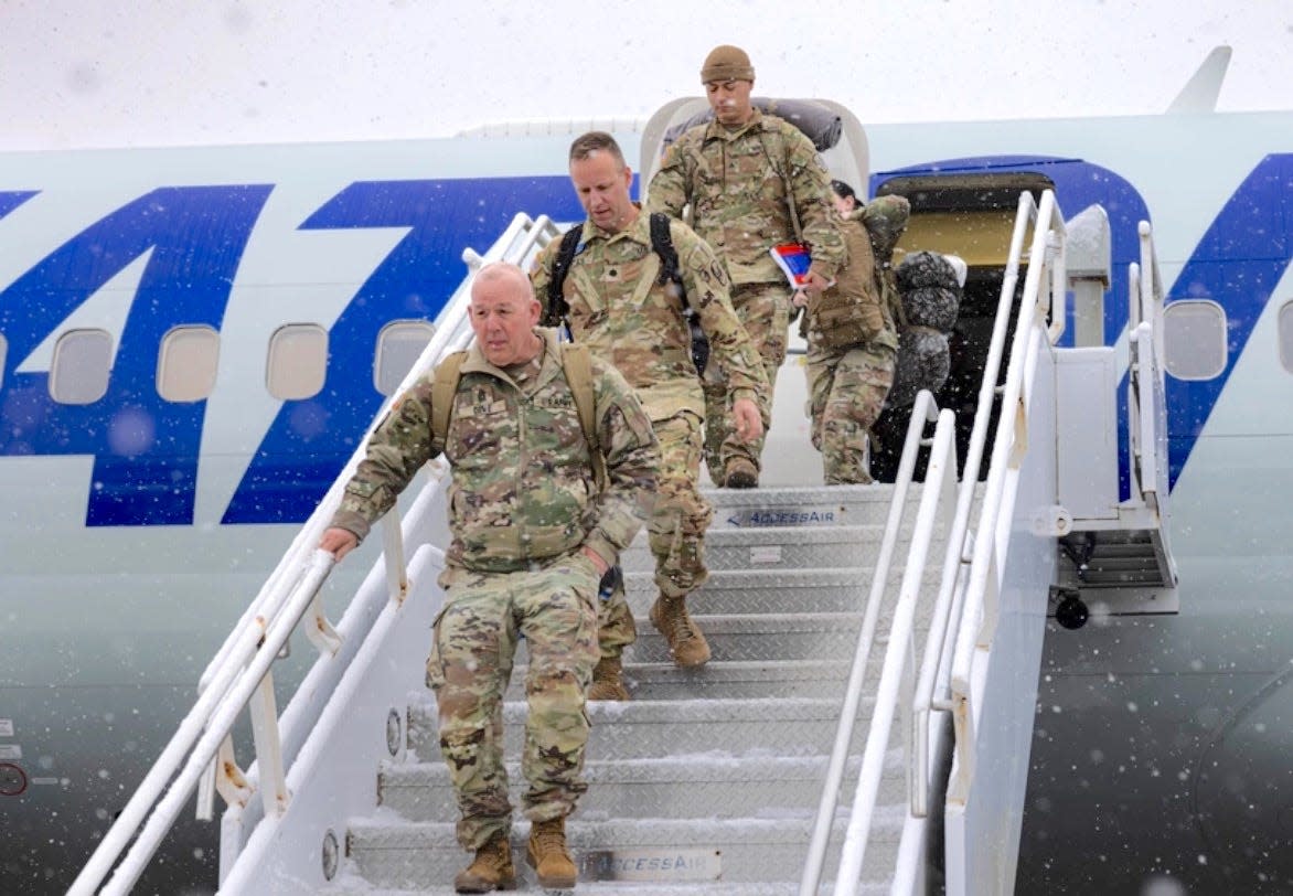 Members of the 1st Battalion, 126th Aviation Regiment, Rhode Island National Guard, debark their charter aircraft at Quonset after having served for 10 months in Kosovo.