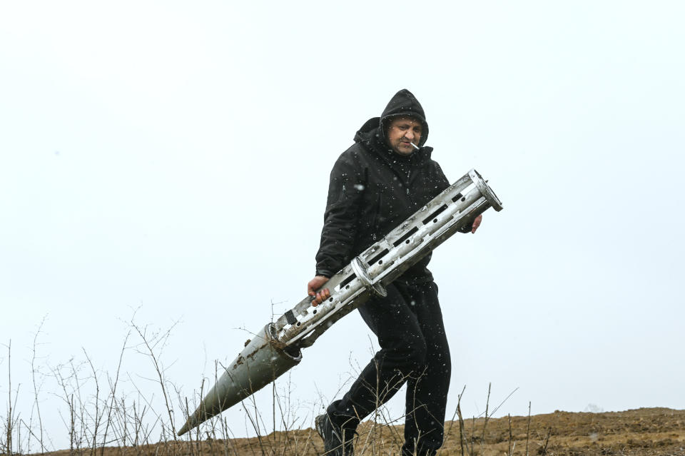 A Ukrainian civilian holds an empty Russian cluster munition rocket (Justin Yau / Sipa via AP file)