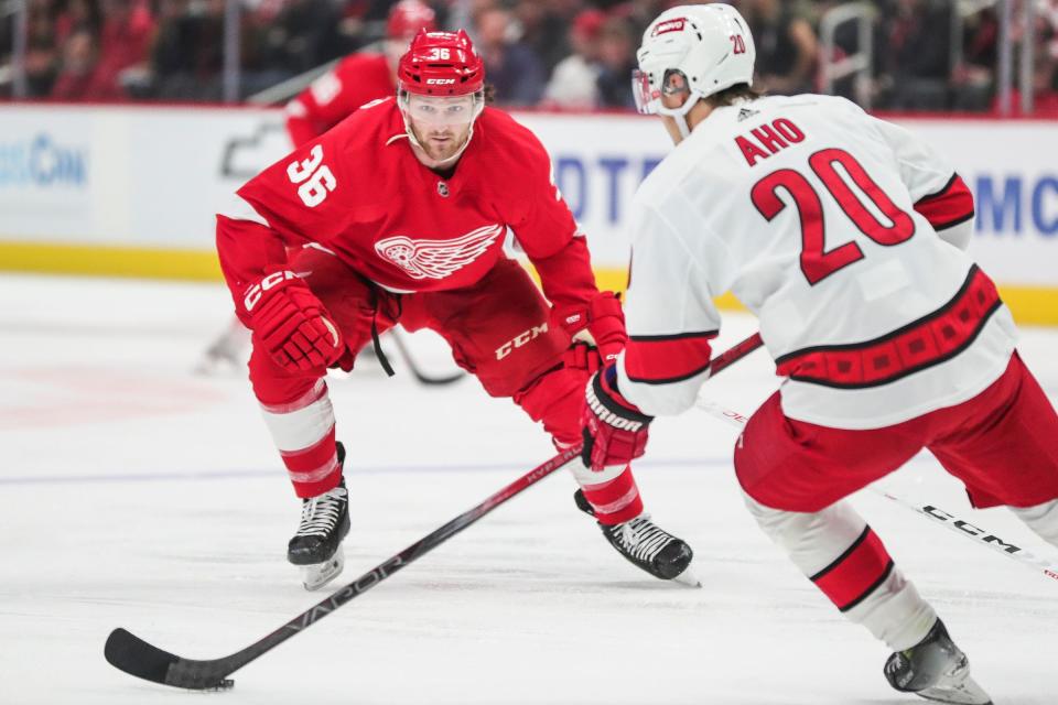 Detroit Red Wings right wing Christian Fischer (36) defends Carolina Hurricanes center Sebastian Aho (20) during the first period at Little Caesars Arena in Detroit on Thursday, Dec. 14, 2023.