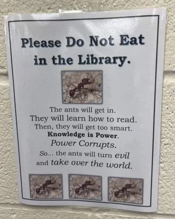 The sign says: "Please do not eat in the library.  The ants will come in, learn to read, become very smart.  Knowledge is power.  Power corrupts.  The ants will become evil."