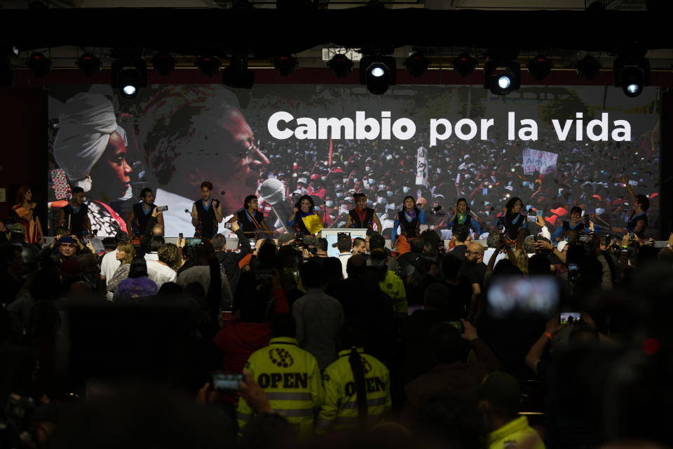 Musicians perform before supporters of Gustavo Petro, presidential candidate with the Historical Pact coalition, on election night in Bogota, Colombia, Sunday, May 29, 2022. Petro will advance to a runoff contest in June after none of the six candidates in Sunday's first round got half the vote. The Spanish phrase reads "Change for life." (AP Photo/Fernando Vergara)