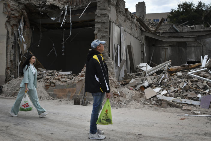 People pass by heavily damaged buildings after latest Russian rocket attack in Dnipro, Ukraine, Monday, Sept. 12, 2022. (AP Photo/Andriy Andriyenko)