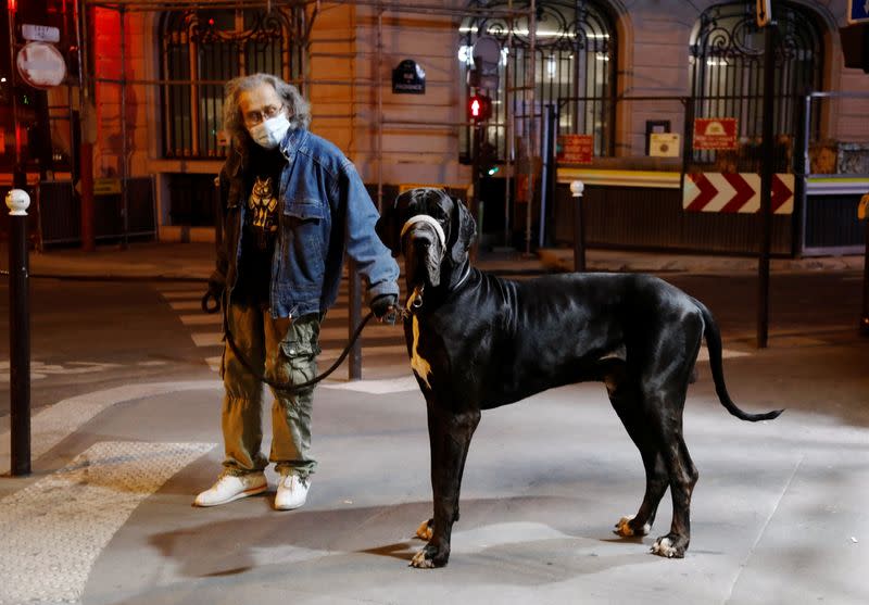 A man walks his dog during the late-night curfew due to restrictions against the spread of the coronavirus disease (COVID-19) in Paris