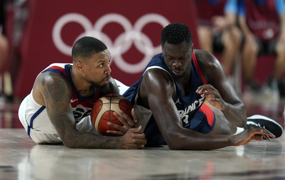 United States' Damian Lillard (6), left, and France's Moustapha Fall (93) fight for a loose ball during men's basketball gold medal game at the 2020 Summer Olympics, Saturday, Aug. 7, 2021, in Saitama, Japan. (AP Photo/Charlie Neibergall)