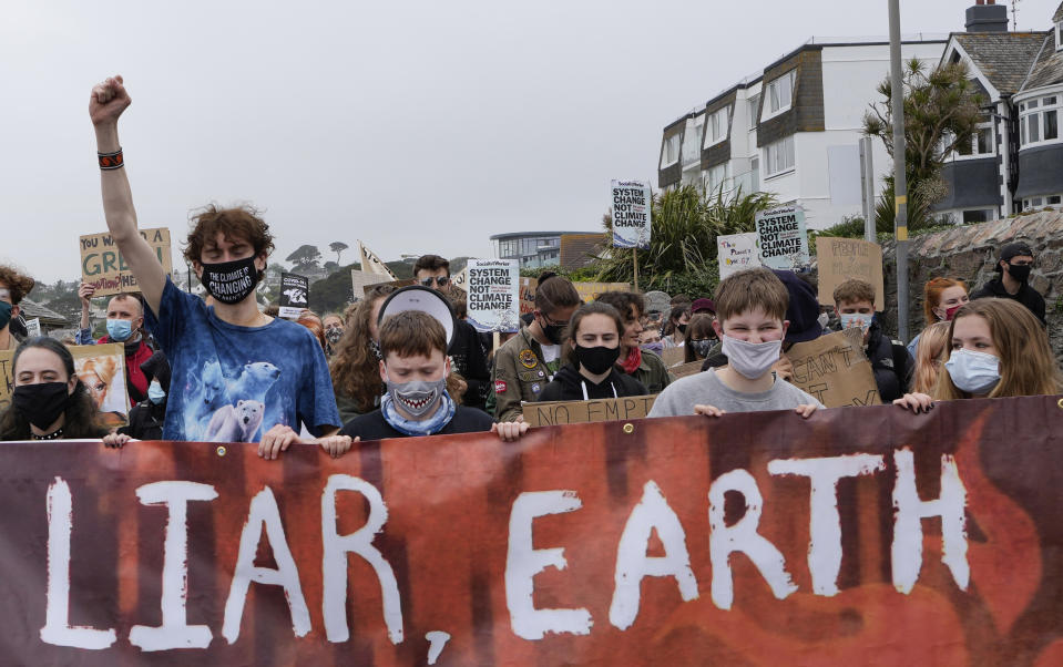 Climate activists hold a banner while marching as they demonstrate as part of Fridays for Future in Falmouth, Cornwall, England, Friday, June 11, 2021. Leaders of the G7 begin their first of three days of meetings on Friday in Carbis Bay, in which they will discuss COVID-19, climate, foreign policy and the economy. (AP Photo/Kirsty Wigglesworth)