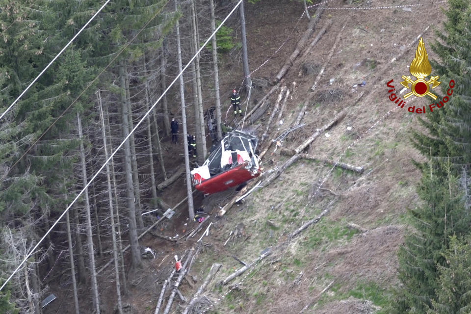 Rescuers work by the wreckage of a cable car after it collapsed near the summit of the Stresa-Mottarone line in the Piedmont region, northern Italy, as seen from the aerial photograph, Sunday, May 23, 2021. Italy’s transport minister was heading Monday, May 24, 2021 to the scene of a cable car disaster that killed 14 people when the lead cable apparently snapped and the cabin careened back down the mountain until it pulled off the line and crashed to the ground. (Vigili del Fuoco Firefighters via AP)