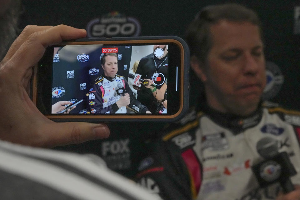 A reporter makes a video interview on his cell phone with Brad Keselowski during NASCAR Daytona 500 auto race media day at Daytona International Speedway, Wednesday, Feb. 15, 2023, in Daytona Beach, Fla. (AP Photo/John Raoux)