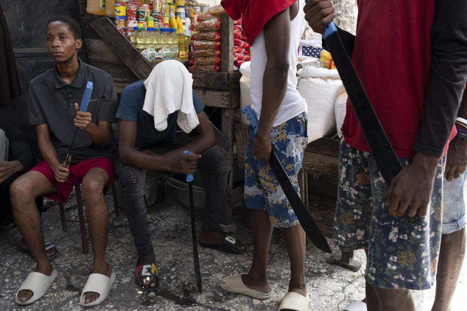 Men with machetes, part of "Bwa Kale," an initiative to resist gangs from getting control of their neighborhood, hold their machetes, in the Delma district of Port-au-Prince, Haiti, Sunday, May 28, 2023. (AP Photo/Ariana Cubillos)