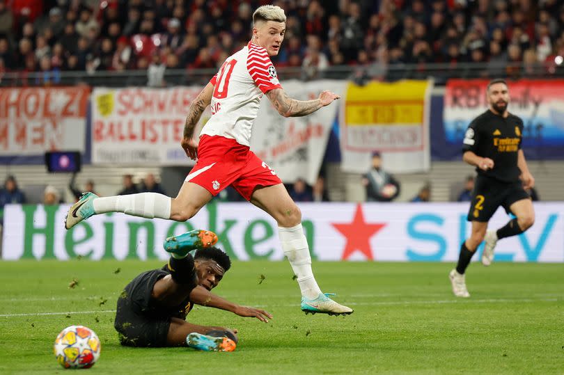 Benjamin Sesko jumps over Aurelien Tchouameni during the UEFA Champions League Round of 16, first-leg  between RB Leipzig and Real Madrid CF