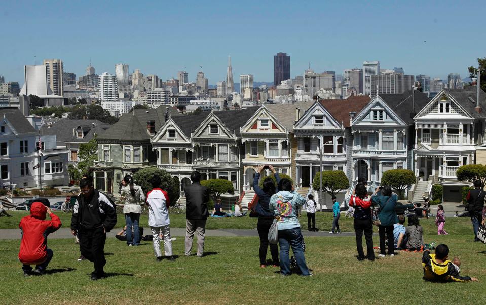 Tourists taking photos of the homes on Alamo Square.