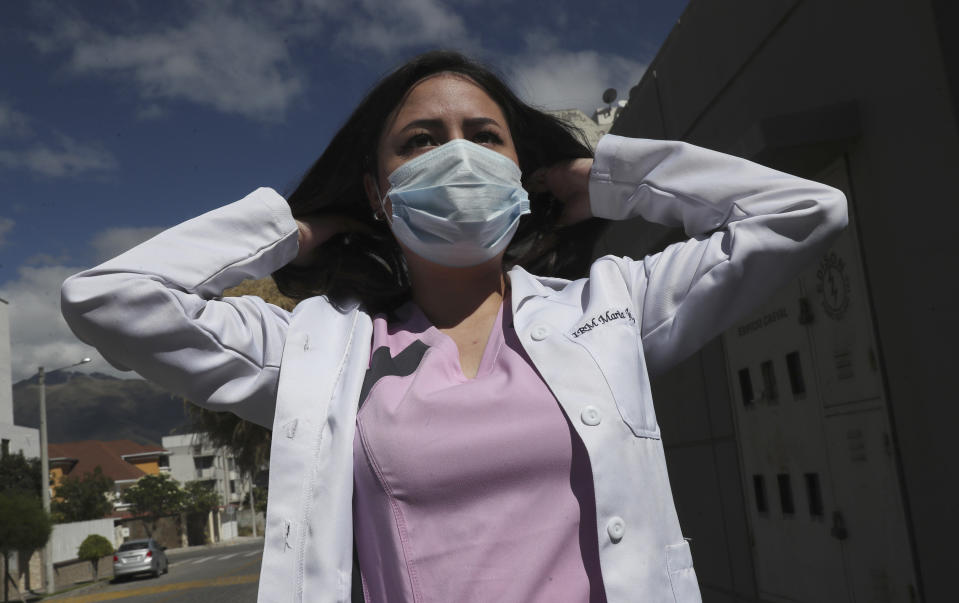 Dr. Maria Jose Casco adjusts her hair as she walks near her home in Quito, Ecuador, Wednesday, Aug. 5, 2020. Around the world, young people armed with new degrees, diplomas and professional qualifications are struggling to enter the workforce as the pandemic pushes the global economy into recession. Maria Jose Casco, a newly qualified doctor, hasn’t found work after graduating in Ecuador in April. Casco, 24, said she’s been searching for health-related jobs as well as work in other industries. (AP Photo/Dolores Ochoa)