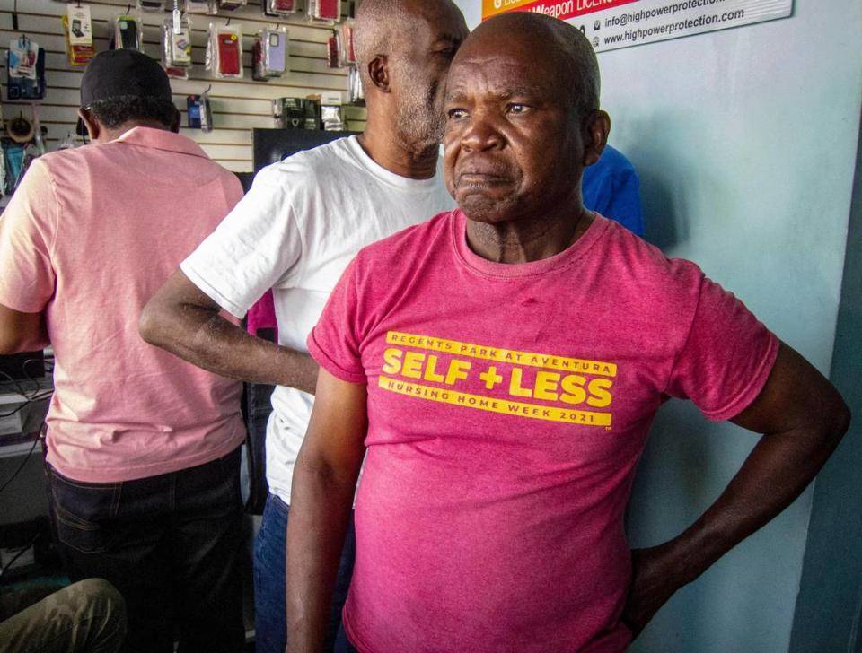 Eliantes Jean Jacques, right, who lost two family members to gang violence in Port-au-Prince pauses after discussing details of his painful loss with a Miami Herald reporter inside Clariteck, a store in North Miami. Jose A. Iglesias/jiglesias@elnuevoherald.com