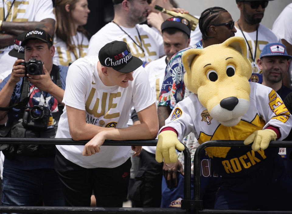 Denver Nuggets center Nikola Jokic, left, jokes with team mascot Rocky during a rally and parade to mark the team's first NBA basketball championship on Thursday, June 15, 2023, in Denver. (AP Photo/David Zalubowski)