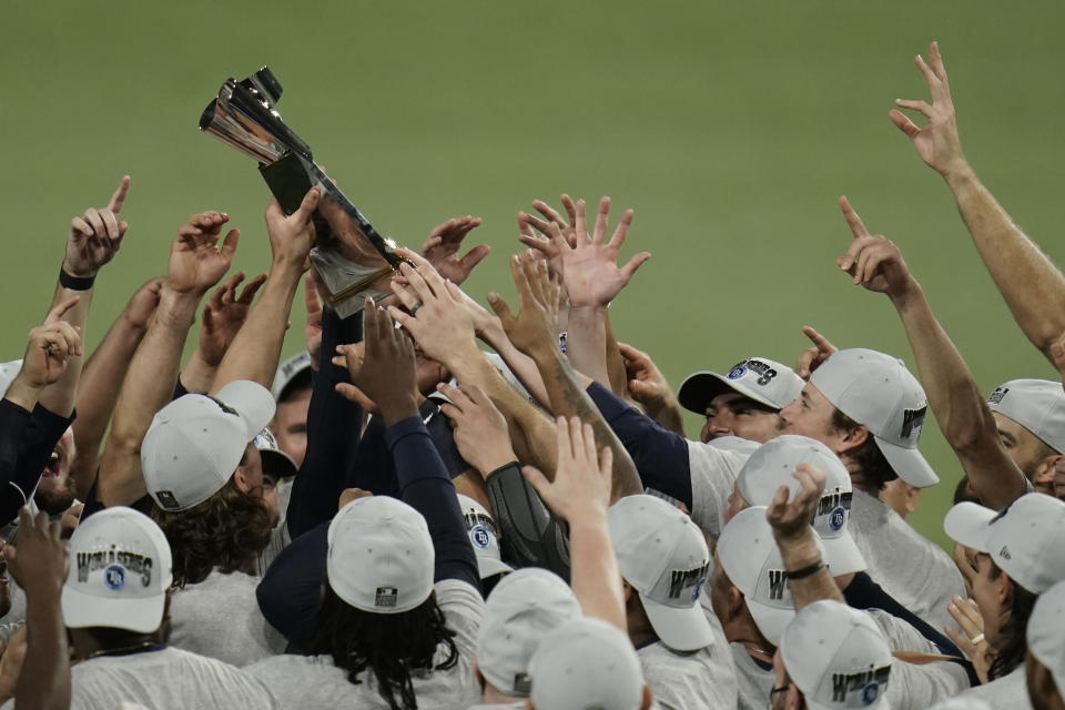 Tampa Bay Rays hold the American League championship trophy following their victory against the Houston Astros in Game 7 of a baseball American League Championship Series, Saturday, Oct. 17, 2020, in San Diego. The Rays defeated the Astros 4-2 to win the series 4-3 games. (AP Photo/Gregory Bull)