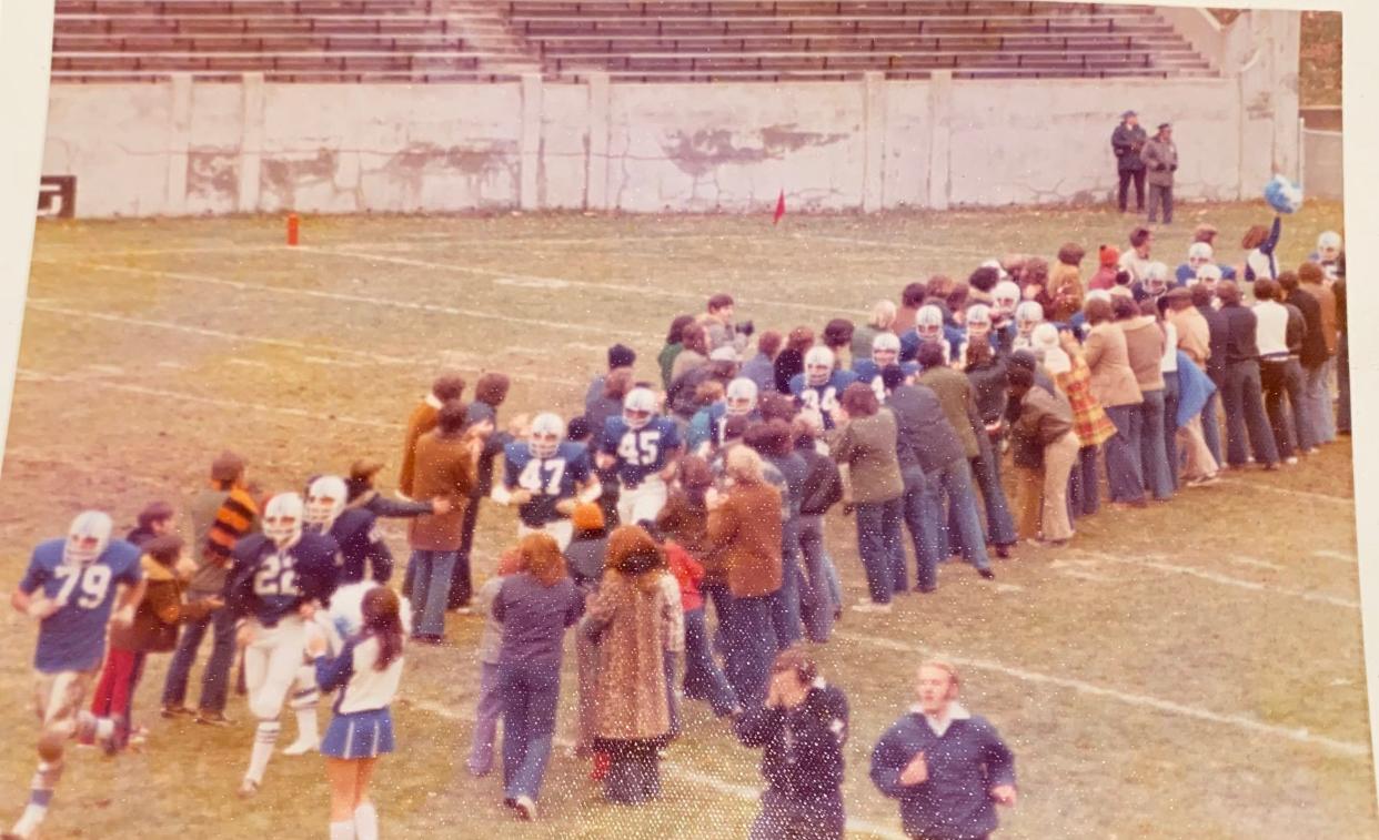 Xavier football players run through a tunnel of Musketeer fans after halftime of the team's game against Northern Illinois on Nov. 10, 1973. Xavier went on to win, 40-36.