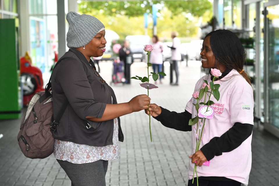 <p>A volunteer hands-out a rose to Jane, from Manchester during a pop-up event hosted by women's health company, Hologic and Prevent Breast Cancer, to launch the 'It's Time' campaign, highlighting the importance of attending breast cancer screenings when eligible, in Manchester. Picture date: Monday October 4, 2021.</p>
